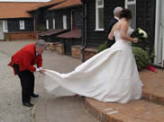 Essex Wedding Toastmaster assists bride with her wedding dress at Vaulty Manor, Essex